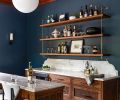 The dining room&rsquo;s new entertainment area features white oak cabinetry, quartzite counters from Galaxy Stone Works Inc., and a handy wine fridge from Eastbank Contractor Appliances. The bar, with rounded stools, is set against bold &ldquo;Narragansett Green&rdquo; walls from Benjamin Moore.