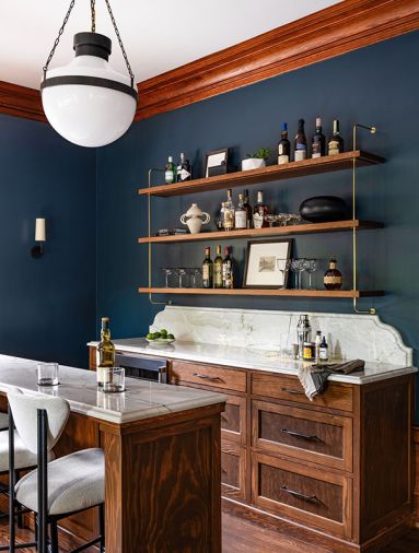 The dining room&rsquo;s new entertainment area features white oak cabinetry, quartzite counters from Galaxy Stone Works Inc., and a handy wine fridge from Eastbank Contractor Appliances. The bar, with rounded stools, is set against bold &ldquo;Narragansett Green&rdquo; walls from Benjamin Moore.