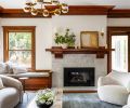 The carefully restored and artfully hewed Craftsman fireplace mantel is balanced with handmade tiles whose natural imperfections catch the light. A rounded Petra Natural Stone coffee table reiterates living room&rsquo;s curved furnishings. Restored original window woodwork pairs with a cozy window seat trimmed with custom Pindler fabric.