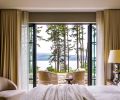 Lighter spaces like the primary bedroom are soft and breathable, offering a sense of calm and quiet expansion. The walls are covered in Apex Linen from Gregorius Pineo paired with custom bed and nightstands, and on the patio, woven swivel chairs from RH.