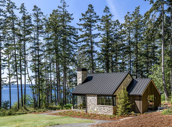 The exterior, with elegant crisp black aluminum windows and doors, and a smooth standing seam metal roof is juxtaposed against Italian salvaged stone. The project focused on weaving in threads from the homeowner&rsquo;s life experience.