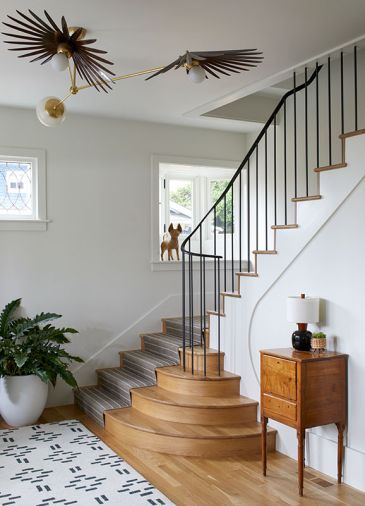 After Olson & Jones Construction gutted this 1910 Portland home, its staircase design was totally reconfigured to include Bright Designlab&rsquo;s sweeping multi-faceted trim and delicate stair railings manufactured by Sterling Steel Company. A Suki Porcini handwoven wool stair runner from Kush Rugs protects new treads. A Rosie Li Inez antique copper finished chandelier echoes the stair railing.