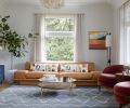 Natural light is abundant from windows restored by East Portland Sash. Color is inserted with Belle Side Chairs from DeMuro Das, a StudioTwentySeven&rsquo;s Moore + Giles sofa, Gulliver Media Console, and custom rug from Taylor Made Textiles.