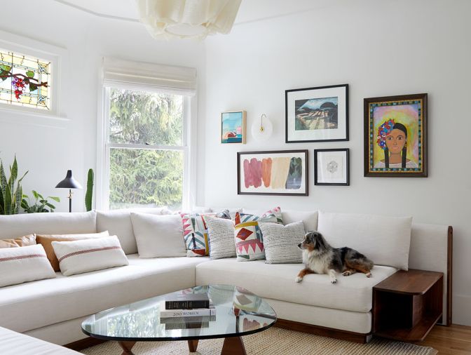Adding comfort, Bright Designlab designed a custom sofa paired with an abaca fiber Anders Pendant from Pinch and a Noguchi coffee table. The historic stained glass window hails from the homeowner family&rsquo;s old home.