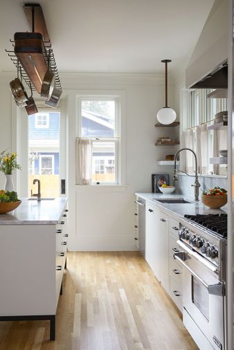 Custom beech cabinetry and a Parison Pendant by Allied Maker brighten the workspace, while Olson & Jones introduced door access to a new patio area from the kitchen.