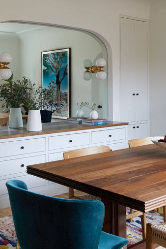 The custom ash built-in with shaker flat front panels and clean subtitle knobs is from Edel Design Center. A mirror above reflects the dramatic &ldquo;Joshua&rdquo; artwork by Kristin Hart Studios.