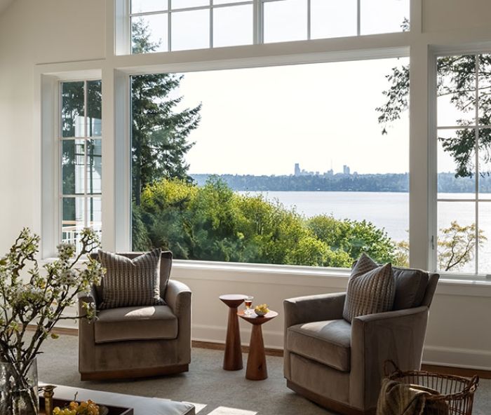 The new family room&rsquo;s Pella windows provide views of Seattle across Lake Washington. The comfy Wesley Hall Fremont swivel chairs and leather Durham storage ottoman are from DFG.