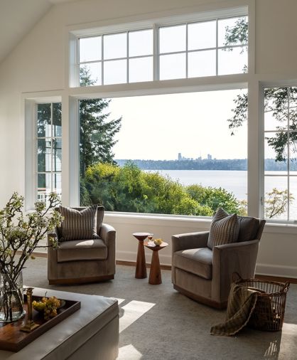 The new family room&rsquo;s Pella windows provide views of Seattle across Lake Washington. The comfy Wesley Hall Fremont swivel chairs and leather Durham storage ottoman are from DFG.