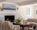 A refinished living room fireplace features Bianco Carrara marble from Stratus Surfaces and the sofas are from Restoration Hardware. The coffee table is fashioned from an antique Indian inlaid brass door.