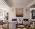 Rima sconces from Cerno flank artwork above two Milo Baughman chairs. The enlarged dining room (left) previously had a swinging door as passage, and the entry (right) now features floor-to-ceiling wainscoting.