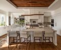Walnut carries through in the tongue and groove ceiling, as well as custom cabinetry from Creative Woodworking, Inc. Brizo faucets and Elkay sinks were sourced from Ferguson Home. The graceful Quartzite Bianco Superiore counters are from Stratus Surfaces.