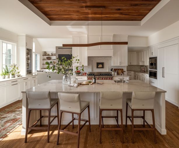 Walnut carries through in the tongue and groove ceiling, as well as custom cabinetry from Creative Woodworking, Inc. Brizo faucets and Elkay sinks were sourced from Ferguson Home. The graceful Quartzite Bianco Superiore counters are from Stratus Surfaces.