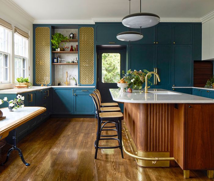 The custom cabinetry throughout the kitchen is designed by Bright Designlab, built by Master Furniture Makers, and painted in &ldquo;Vanderberg Blue&rdquo; from Benjamin Moore. The bespoke island has a quartzite counter, fluted details, brass accents, and is lit by Gino Sarfatti pendants.