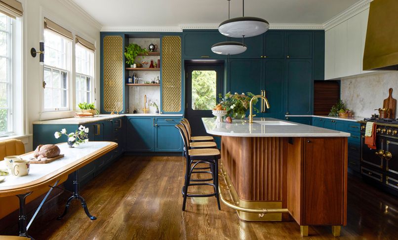 The custom cabinetry throughout the kitchen is designed by Bright Designlab, built by Master Furniture Makers, and painted in &ldquo;Vanderberg Blue&rdquo; from Benjamin Moore. The bespoke island has a quartzite counter, fluted details, brass accents, and is lit by Gino Sarfatti pendants.