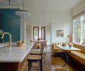 The homeowner now has garden views from the sink and can visit with guests seated in cane Hoffman barstools from DWR (Design Within Reach). A custom yellow leather banquette was built by Master Furniture Makers and was paired with a tabletop with a vintage base.