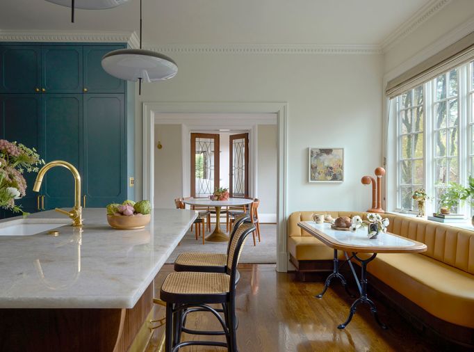 The homeowner now has garden views from the sink and can visit with guests seated in cane Hoffman barstools from DWR (Design Within Reach). A custom yellow leather banquette was built by Master Furniture Makers and was paired with a tabletop with a vintage base.