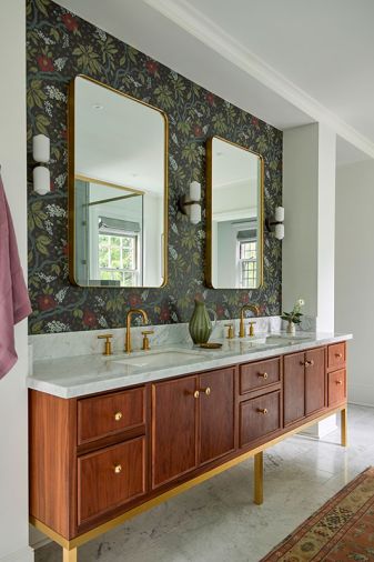 The custom walnut vanity with honed marble counter is designed by Bright Designlab with lacquer and finishing by Master Furniture Makers. The wall sconces were sourced from In Common With, brass mirrors from Rejuvenation, and Purist plumbing fixtures from Kohler.