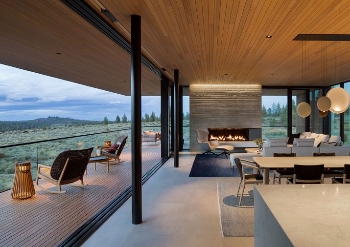 The home&rsquo;s key grounding architectural element is its stunning board-formed concrete chimney by Deschutes Concrete. A 40' Glasbox slider opens interiors to an Ipe deck with Gloster Kay High Back Rocking Chairs.