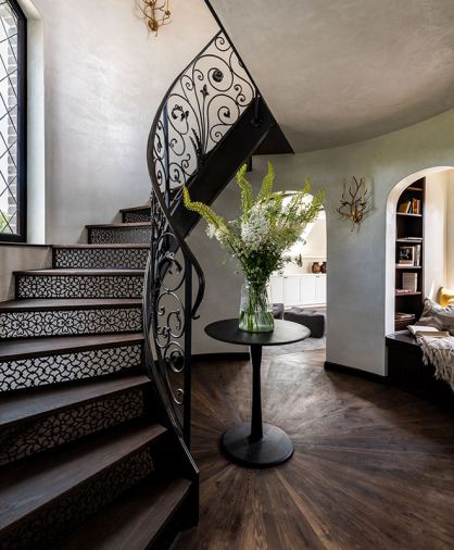 The custom staircase was designed and fabricated by Twisted Metalworks, Inc, with tile from the Pacific Register Company. The engineered wood floors are from Simply Oak, and the Branch sconce was sourced at Visual Comfort & Co.