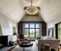 The living room was one of the beautiful original spaces the team wanted to preserve. The interior plasterwork was painted &ldquo;Floral White&rdquo; from Benjamin Moore, while the fireplace has a custom stucco surround. From the ceiling hangs a Scheherazade 3 Tiers Herbarium Silk Lamp from Fortuny.