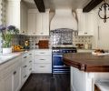 The ceramic tile backsplash in the kitchen is from Solar Antique Tiles, including the Portuguese Full Mural Reproduction behind the stove, tying in the La Cornue range. The perimeter counters are polished quartzite from Arizona Tile, while the island has custom walnut butcher block. The Artifacts faucet and Riverby sink are both from Kohler.
