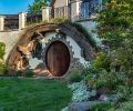 The Hobbit door is a delight for all who find it. The custom pivot door was designed and crafted by Thomas Fragnoli Construction. It&rsquo;s surrounded by concrete made to look like a curved wooden timber, with tufts of grasses tucked around it.