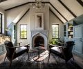 In the sitting room, the custom casework is from Scott Faulkner Design with knobs from House of Antique Hardware. The fireplace is cast plaster, with a Glass Star Chandelier above. At the window seat, there&rsquo;s a Princeton Mid Sconce in natural brass from Schoolhouse.