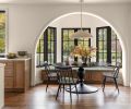 The breakfast nook in the kitchen has windows from Kolbe Gallery Seattle and a window seat built onsite by European Custom Cabinets with a custom stain. The light over the table is the Elliot Grande Pendant in &ldquo;Portland Gray&rdquo; from Visual Comfort & Co. The homeowner provided the table and chairs.