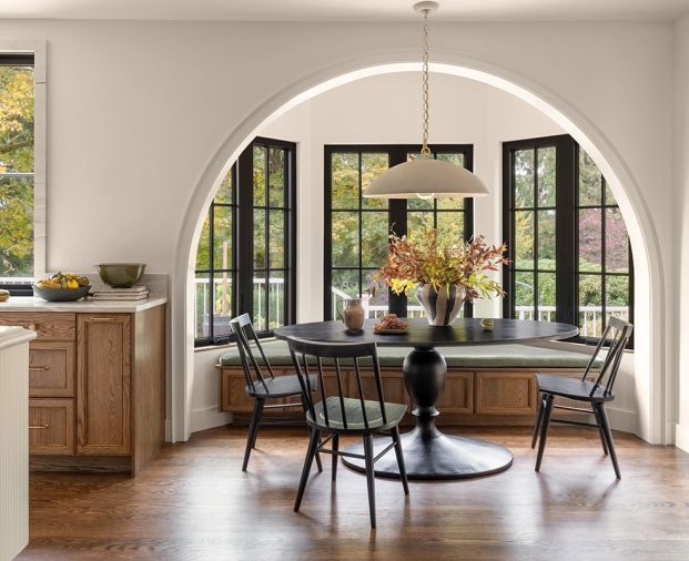 The breakfast nook in the kitchen has windows from Kolbe Gallery Seattle and a window seat built onsite by European Custom Cabinets with a custom stain. The light over the table is the Elliot Grande Pendant in &ldquo;Portland Gray&rdquo; from Visual Comfort & Co. The homeowner provided the table and chairs.