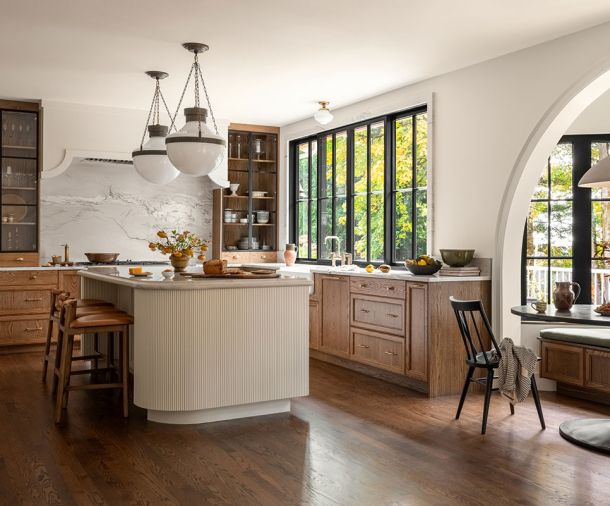 The cabinetry throughout is from European Custom Cabinets, including the reeded paneling on the island. Lind chose the Modern Schoolhouse Lantern from Visual Comfort & Co. to hang over the island.
