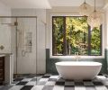 In the primary bathroom, the walls have a textural fluted tile from Z Collection, limewash in &ldquo;Parliament&rdquo; from Portola, and custom wainscoting. The oval soaking tub from Ferguson Home is a solid surface stone resin in &ldquo;Matte White.&rdquo;