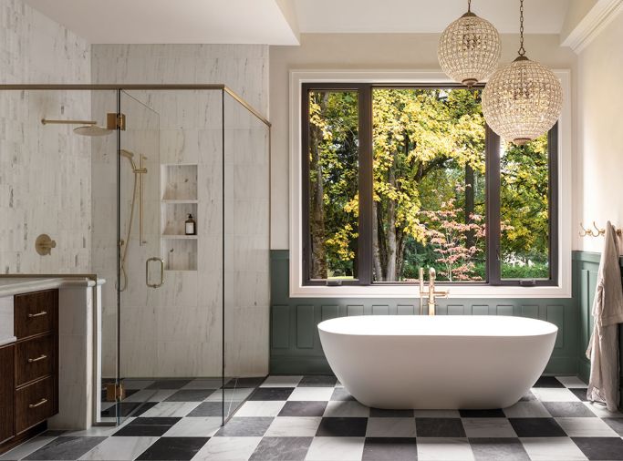 In the primary bathroom, the walls have a textural fluted tile from Z Collection, limewash in &ldquo;Parliament&rdquo; from Portola, and custom wainscoting. The oval soaking tub from Ferguson Home is a solid surface stone resin in &ldquo;Matte White.&rdquo;