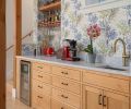 The beverage center, supported by alder cabinetry and Carrara marble counters, includes Everitt&rsquo;s favorite luxuries; a beverage fridge, coffee station, instant hot water, and playful wallcovering from Ballard Designs.
