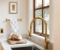 In the kitchen, an unlacquered brass Segovia faucet and Taj Mahal quartzite from Bedrosians Tile & Stone infuse patina and nuance.