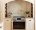 The warm paint tone offers a welcoming, timeless hue on the cabinetry. The polished brass pulls are an elegant recurring detail throughout, adding shine and polish to the space.