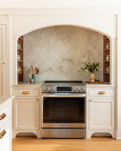 The warm paint tone offers a welcoming, timeless hue on the cabinetry. The polished brass pulls are an elegant recurring detail throughout, adding shine and polish to the space.