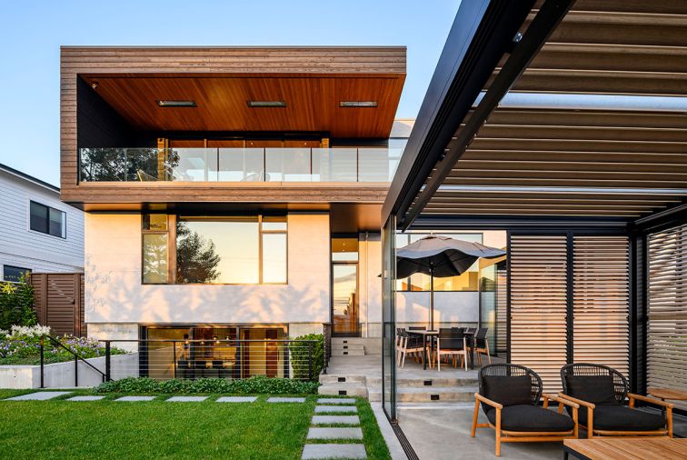 The outdoor rooms, including a kitchen, dining area, and lounge, were master planned with Steven Yavanian. The dining area has a table and chairs from Summer House. The house&rsquo;s flat roof is from Stoneway Roofing, joined with Ceraclad Panasonic siding.