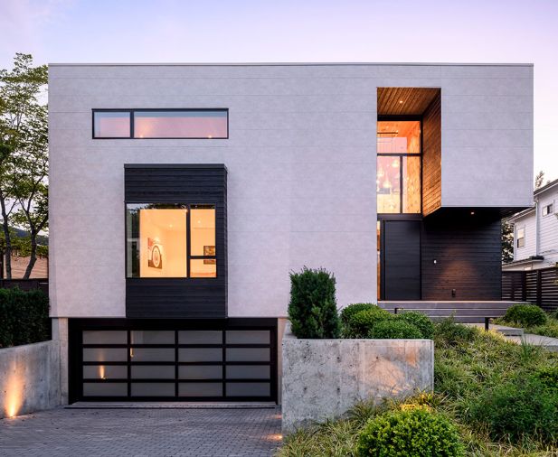At the front of the home, there&rsquo;s a garage door from National Door. The architect specified Shou Sugi Ban siding in Gendai Black from Nakamoto Forestry, to wrap the bay window and entry, and contrast with the white cementitious panels.