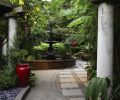 A three-story cast iron fountain is, in many ways, the garden’s centerpiece. Cast concrete, such as the fountain’s base and the tall columns, are one of the couple’s favorite materials. Hardy banana trees and other tropical plants overlook the area and provide shade and shelter.