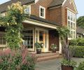 The front porch of the Hartzman-John home is flanked by the climbing rose ‘Compassion’, a modern rose that blooms all summer with a lovely old rose scent that can carry throughout a garden.