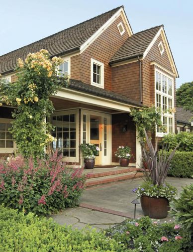 The front porch of the Hartzman-John home is flanked by the climbing rose ‘Compassion’, a modern rose that blooms all summer with a lovely old rose scent that can carry throughout a garden.