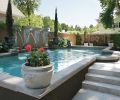 Dark espresso colored stucco outlines the raised 14’x 36’ pool that spans the Brennekes back yard. Putting together the pre-cast pool pieces to create squared off corners took great mathematical precision, says landscape architect Craig Kiest. Lisa plants the colorful seasonal flowers for the pool’s corner pots, as well as the heirloom roses in the bed at left, grown from seed in St. Paul, Oregon.