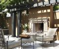 The outdoor gas fireplace is handsomely offset by a dark espresso stained arbor that reiterates the espresso colored stucco from the nearby pool.