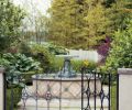 Boxwood and topiary are seen again in the larger garden, and even in the intimate courtyard, accessed from the motor court, which features a charming fountain designed by Larry Cavender.