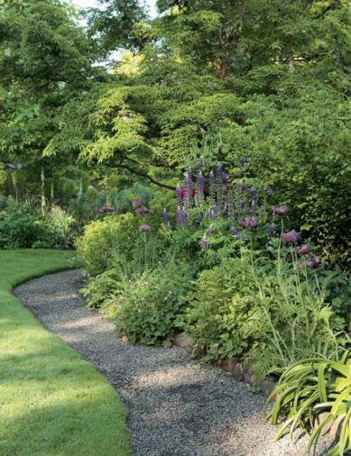 Susan Bates has wisely outlined the perennial borders with a wide fringe of gravel, so that she and her guests can give flowering plants a close inspection. Easy access to plants makes their maintenance easier. The gravel also saves wear and tear on the lawn, and keeps mowers from nicking precious plants. The packed gravel provides firm, non-muddy footing.