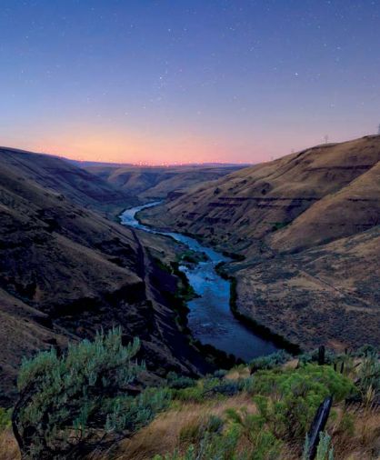 The rugged beauty of lower Deschutes River looking north across the Columbia River toward the distant windmills in Goldendale, Washington.