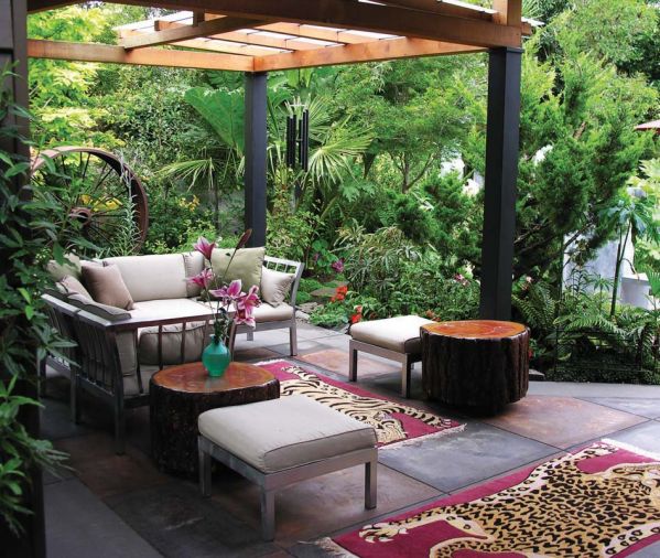 Schultz has created a casual outdoor room, complete with a fragmented roof, which he designed and built with the help of his friend Jim Bauer. The stainless steel couches and seats are covered with off white upholstery. The side tables are large rounds that Schultz salvaged from some downed Douglas firs, and the hand-woven rugs were a gift from a friend from Nepal. The rich burgundy is the perfect backdrop for the lively leopard and tiger patterns. They are just the right finishing touch to this tropical paradise.