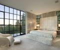 The master bedroom was built at an angle from the rest of the home to both nestle into the tall fir tree forest and to offer a different perspective on the south views across the landscape. A sense of tranquility is fostered with the use of natural textiles and a neutral palette. The room was designed to be much more intimate than the rest of the house. The master bed was custom fabricated by Manion Company.