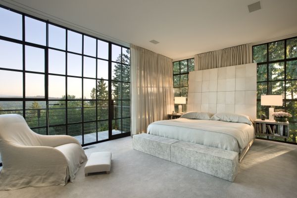 The master bedroom was built at an angle from the rest of the home to both nestle into the tall fir tree forest and to offer a different perspective on the south views across the landscape. A sense of tranquility is fostered with the use of natural textiles and a neutral palette. The room was designed to be much more intimate than the rest of the house. The master bed was custom fabricated by Manion Company.