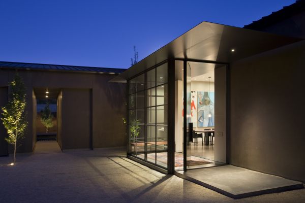 A walled entry court provides the homeowners and their guests an opportunity to shift from the energy of the wider world to the shelter of the hilltop site. Decomposed granite was used as a practical organic paving material in the entry auto court, while hornbeam trees were planted to provide a simple and vertical contrast to the horizontal lines of the garage, entry and house.